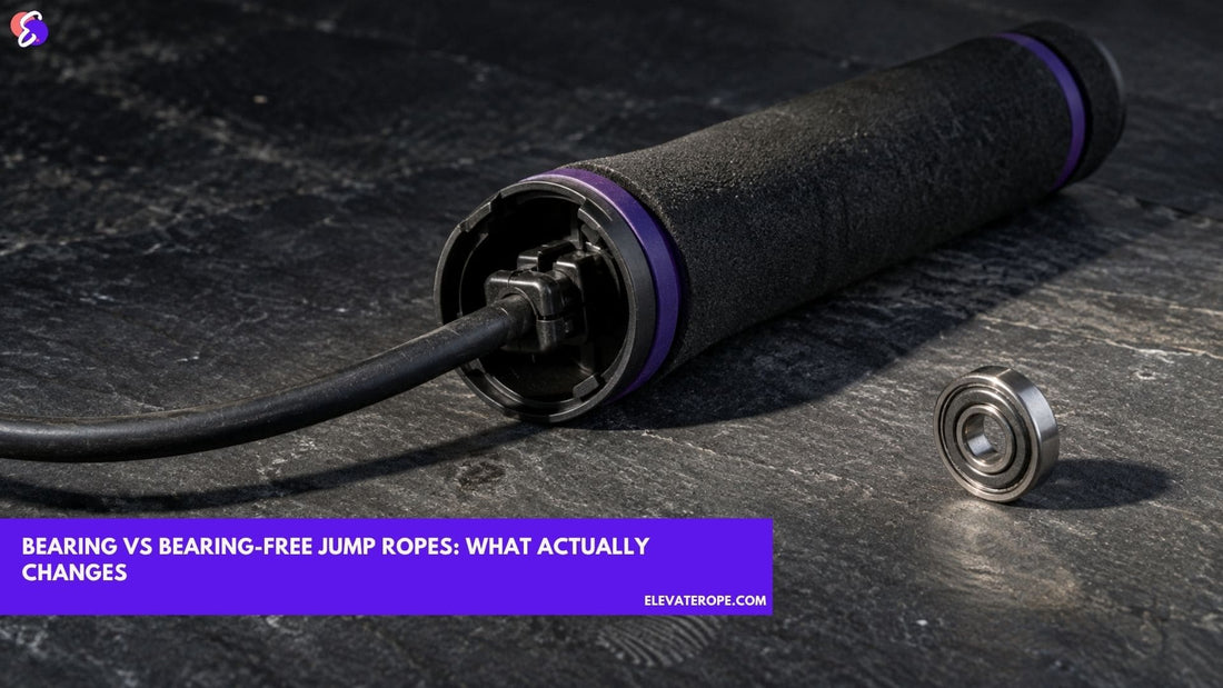 An opened jump rope handle showing the cable fixed by a snaplock, with a single steel ball bearing lying separately on the worktop beside it.