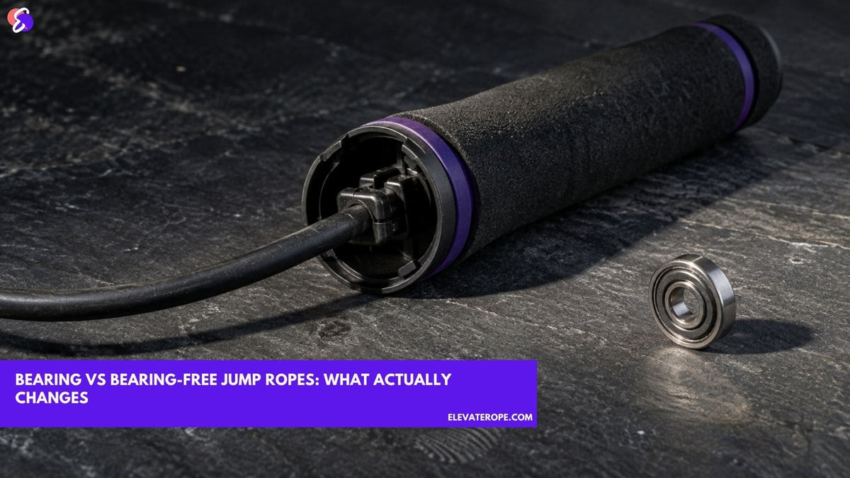 An opened jump rope handle showing the cable fixed by a snaplock, with a single steel ball bearing lying separately on the worktop beside it.