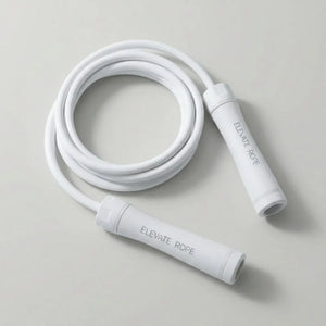 White jump rope with ergonomic handles on a light background, fitness equipment